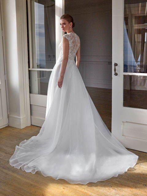 This organza gown with Chantilly lace and beadwork features an A-line silhouette and a V-neckline—a proposal that gracefully blends tradition and modernity.