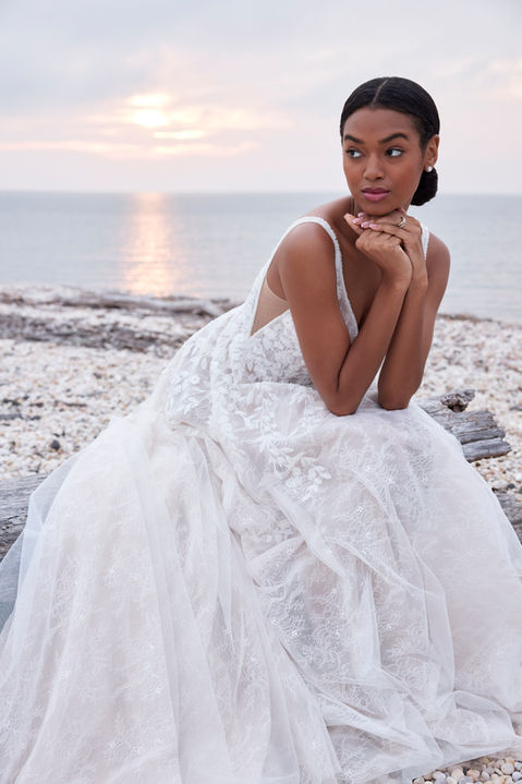Our Song designer wedding dress is a symphony of beauty. The flowing A-line gown has a sculptured v-neckline that draws the eye down in a sultry plunge with beautiful beaded trim and a matching v-shape back that shows off the perfect amount of skin. Embroidered lace has a botanical design, featuring pops of three-dimensional appliqués, over the floral motif of romantic Chantilly lace.