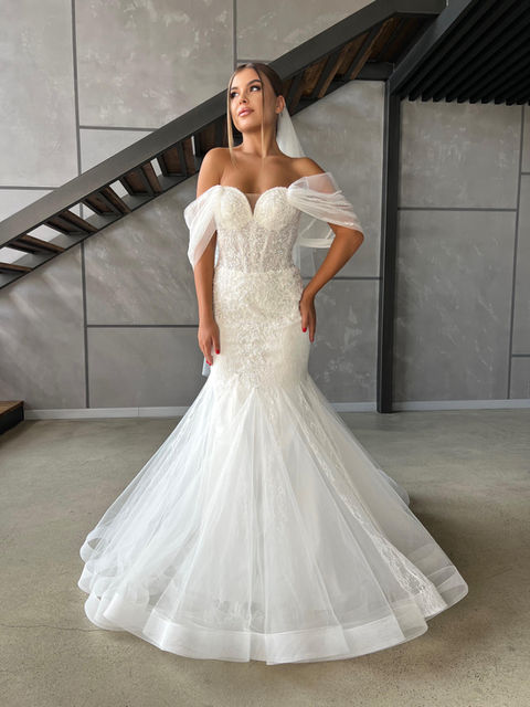 This dramatic lace and tulle mermaid wedding dress has a sweetheart neckline, off shoulder tulle straps and detachable sleeves.