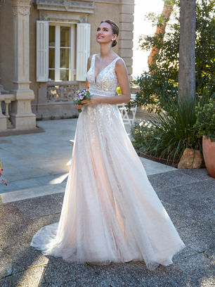 Tulle design with Chantilly lace, embroidery, and beadwork. The A-line silhouette and V-neckline with open back offer a fresh, sophisticated proposal for a confident bride.