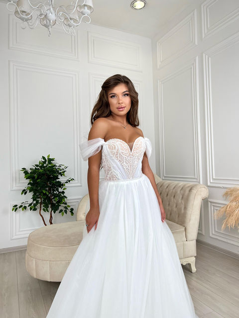 A fairytale princess wedding dress with a full glitter tulle skirt, sweetheart neckline, tulle off-shoulder straps and a beaded bodice with lace decoration. This dress has no train.