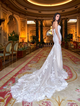 Structured sensuality. Lace-covered tulle hugs the body with precision, while the long train adds drama. The strapless neckline brings balance and sophistication to a powerful silhouette.