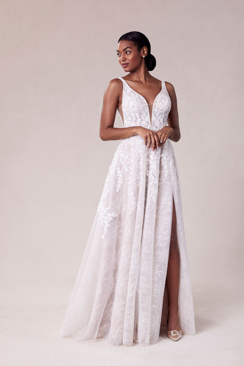 Our Song designer wedding dress is a symphony of beauty. The flowing A-line gown has a sculptured v-neckline that draws the eye down in a sultry plunge with beautiful beaded trim and a matching v-shape back that shows off the perfect amount of skin. Embroidered lace has a botanical design, featuring pops of three-dimensional appliqués, over the floral motif of romantic Chantilly lace.