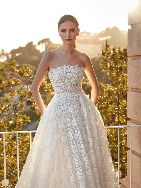 Crafted in guipure, this gown with a princess silhouette and strapless neckline is a statement of classic style with a contemporary flair.
