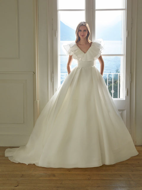 A princess gown in organza with a V-neckline and V-back—evoking romance and freshness in every movement.