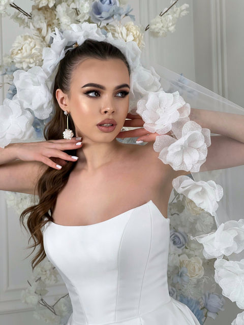 This sexy strapless style features a structured cat eye bodice and is made from soft satin. There is also a small train at the back of the dress for a touch of drama.