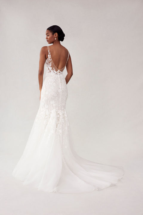 Our Sydney designer wedding dress is classic bridal beauty. The fitted gown has a plunging v-neckline that elongates the body and draws the eye down to the flared tulle skirt. Delicate floral embroidered lace appliqués have a feminine and romantic feel, accenting the sheer open back and climbing up the straps. Godet insets on the train add texture and drama.