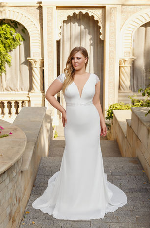 A chic wedding dress with a plunge V-neckline, featuring a low cutout back complemented by transparent lace. The skirt is made from soft chiffon with a short train. The dress also has cap sleeves and a shiny belt.