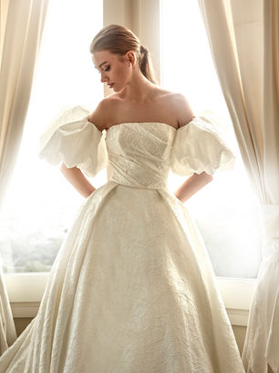 Princess silhouette design in jacquard with a strapless neckline. Its structure and volume make it a majestic choice for a bride who wants to stand out with elegance.