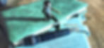 uncapped roller ball pen with emerald green coverstock body on closed journals