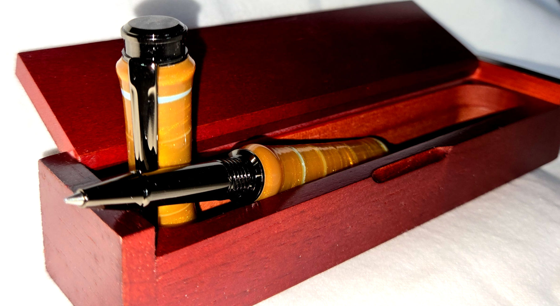 Gold colored pen in wooden box