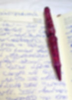 Red, blue and purple colored pen on open journal pages with writing