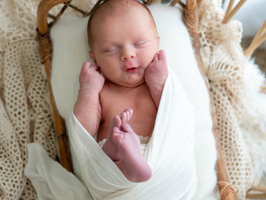 newborn baby swaddled in white wrap sleeping peacefully in basket at Lemon Drop Studio McKinney by Sweet Country Photography