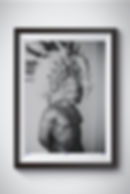 Black-and-white photo of a shirtless man with a feathered headdress, displaying strength and confidence.