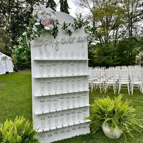 White arch champagne wall with LED neon sign and florals, Seven Wonders Event Rentals, Westchester County, NY