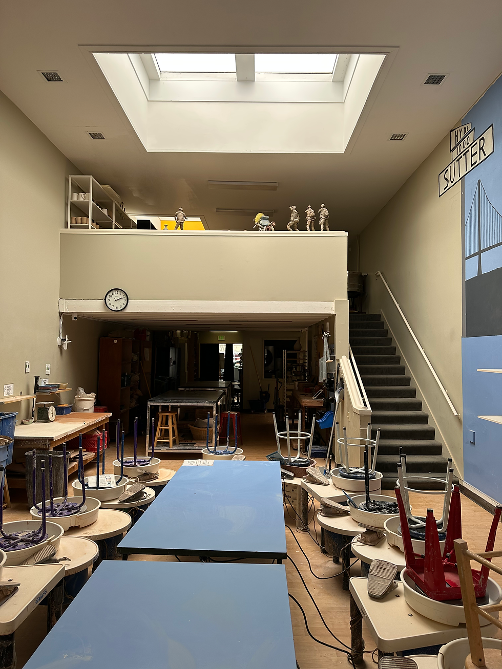 Eye-level view of a bright and spacious art studio with easels and canvases