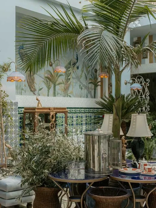 Interior terrace with palm trees, tiled walls, and relaxed ambiance at Villa Aaron in Marrakech’s Kasbah