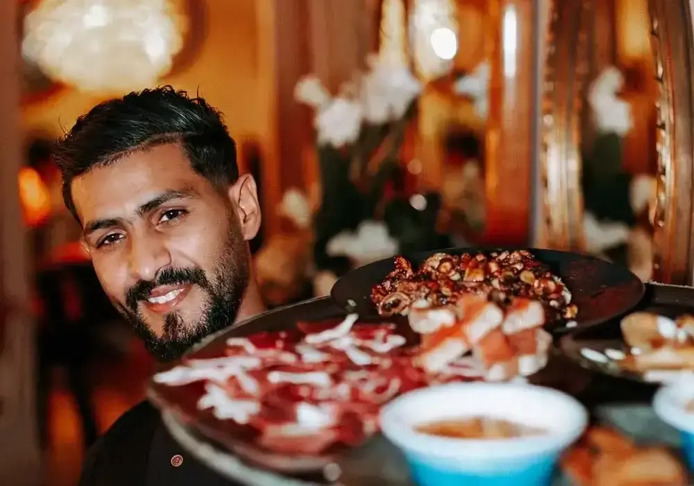 Smiling waiter at Dar Baba Essaoura, signature restaurant of Amazoz Hospitality Group.