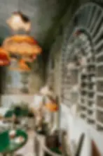 Refined tea salon corner at Villa Aaron with vintage chandeliers, porcelain wall display, and elegant table service in Marrakech