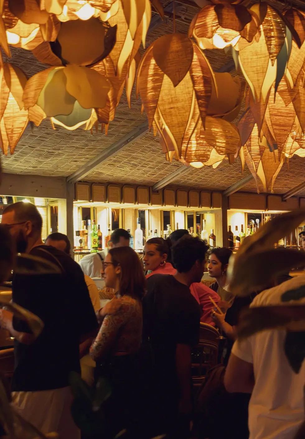 Des clients profitent de cocktails et de l'ambiance chaleureuse du bar Rooffloor à l'intérieur du Kabana Rooftop Marrakech