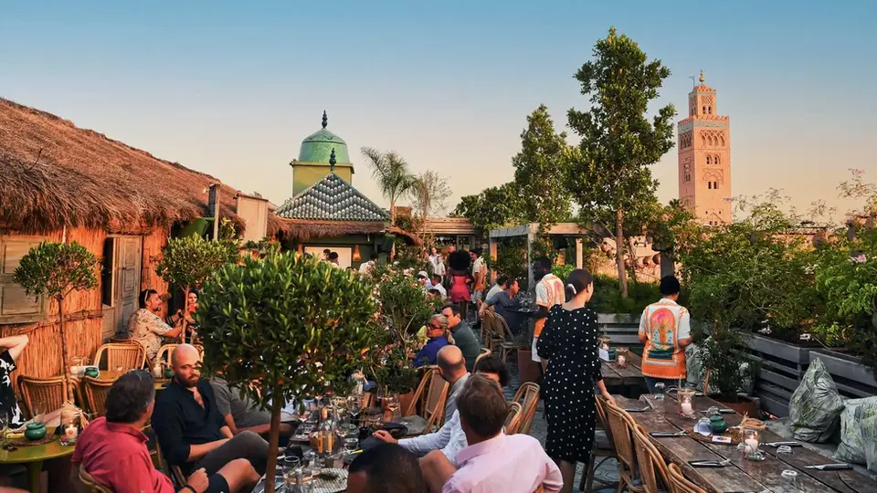 Panoramic view of Kabana's main rooftop area with view on the Koutoubia, at sunset.