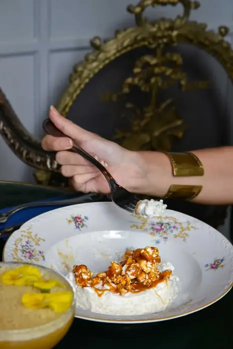 Close-up of a dessert topped with caramel popcorn and cream at Villa Aaron
