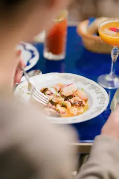 Plat de fruits de mer avec radis et cocktail sans alcool sur une table bleu foncé à la Villa Aaron