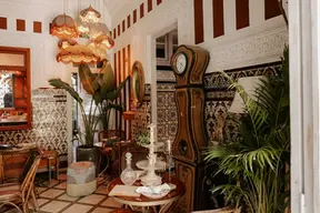 L'intérieur de style riad de la Villa Aaron avec horloge ancienne, murs en zelliges et décoration vintage dans la médina de Marrakech