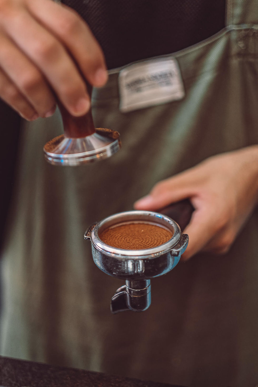 Barista preparing specialty coffee at Mandala Koutoubia, tamping freshly ground coffee for an espresso in Marrakech.