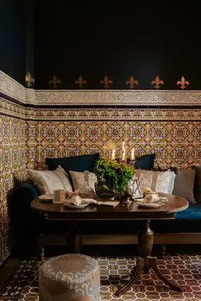Coin salon confortable de style Kasbah à la Villa Aaron, avec des carreaux de zellige marocains traditionnels et une table élégante