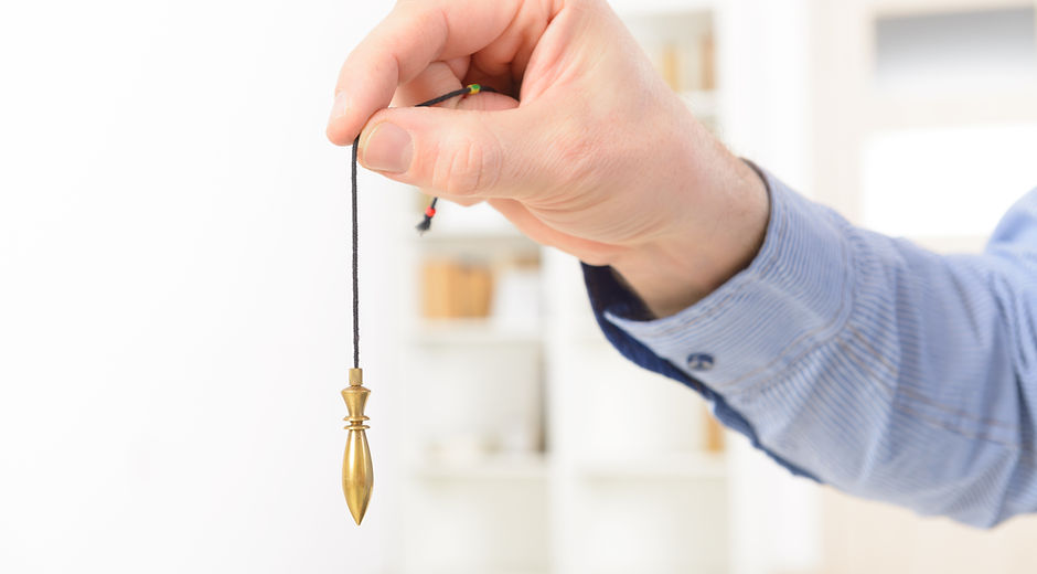 Hand Holding Pendulum
