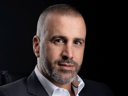 איש עסקים בחליפה כהה בצילום תדמית מקצועי — תאורה סלקטיבית על רקע כהה, שרון גבאי צלם תדמית