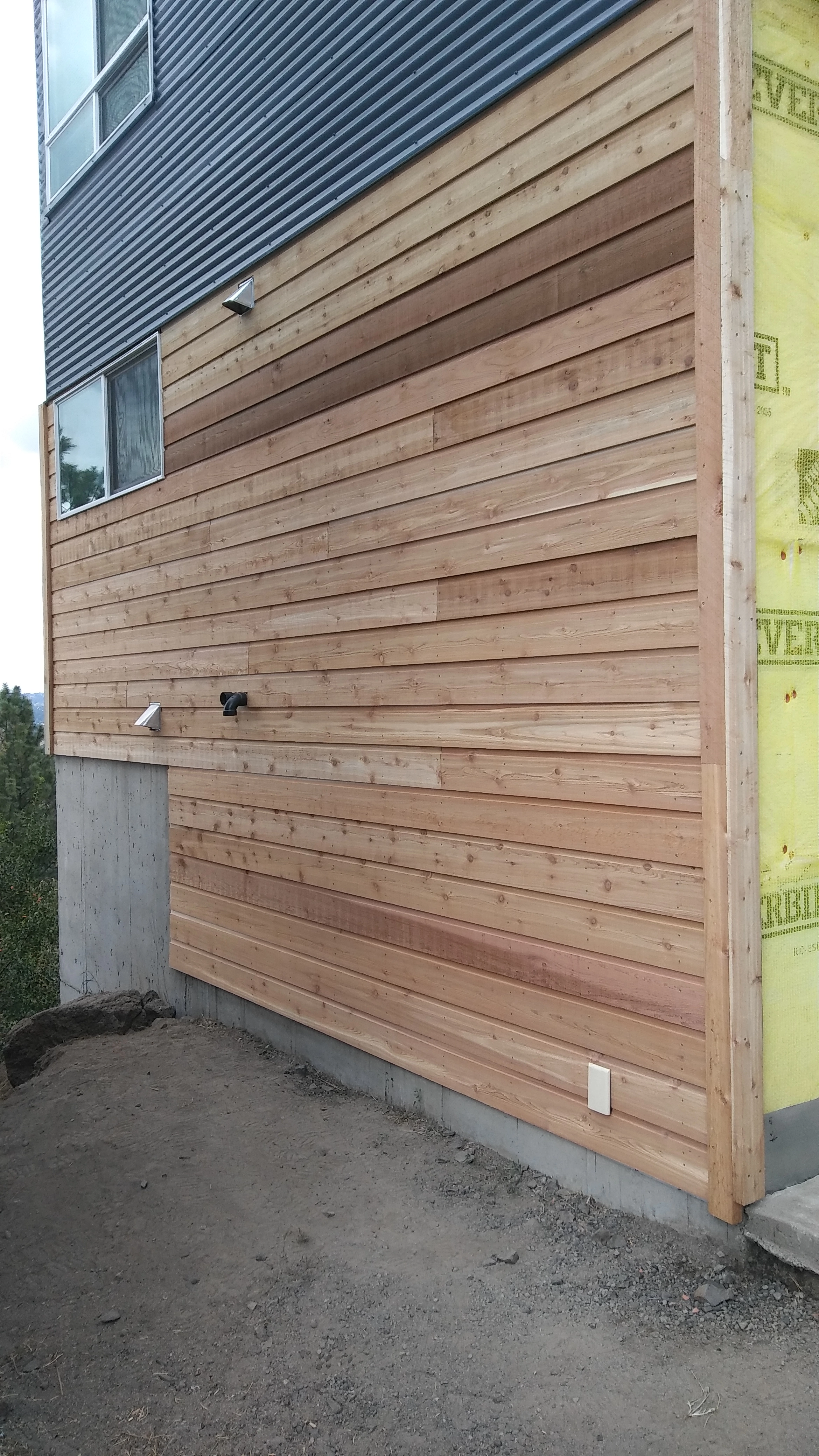 Expertly installed Cedar wood channel siding showcased in close-up detail. This image highlights the beauty of our craftsmanship, with meticulous attention to detail in each cut and placement of the siding. The natural beauty of the bare wood shines through, making your home truly unique and stunning