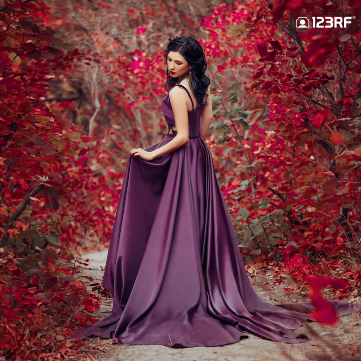 Stock Photo - The beautiful elf in a long blue dress is walking in a green forest full of branches, ,Princess in vintage dress, the queen of the forest,fashionable toning,creative computer colors
