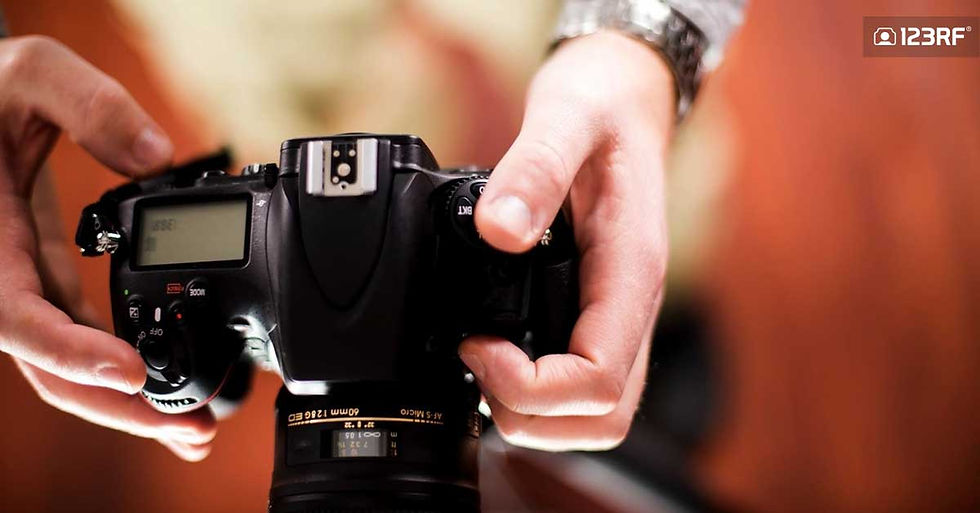 Stock Photo - Professional Camera in Hands of Photographer. Photography Theme. Top View - Male Hands. Technology Photo Collection.