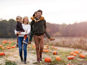 Halloween stock photo of a family walking through a pumpkin patch at golden hour