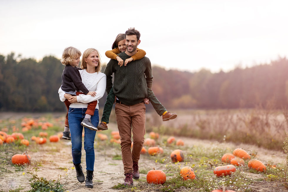 Halloween stock photo of a family walking through a pumpkin patch at golden hour