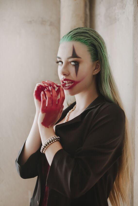 young woman with joker makeup and costume. cosplay photo