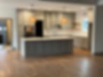 Modern kitchen with gray cabinets, large island, and wood floor