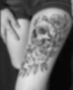 Detailed skull and rose tattoo on thigh