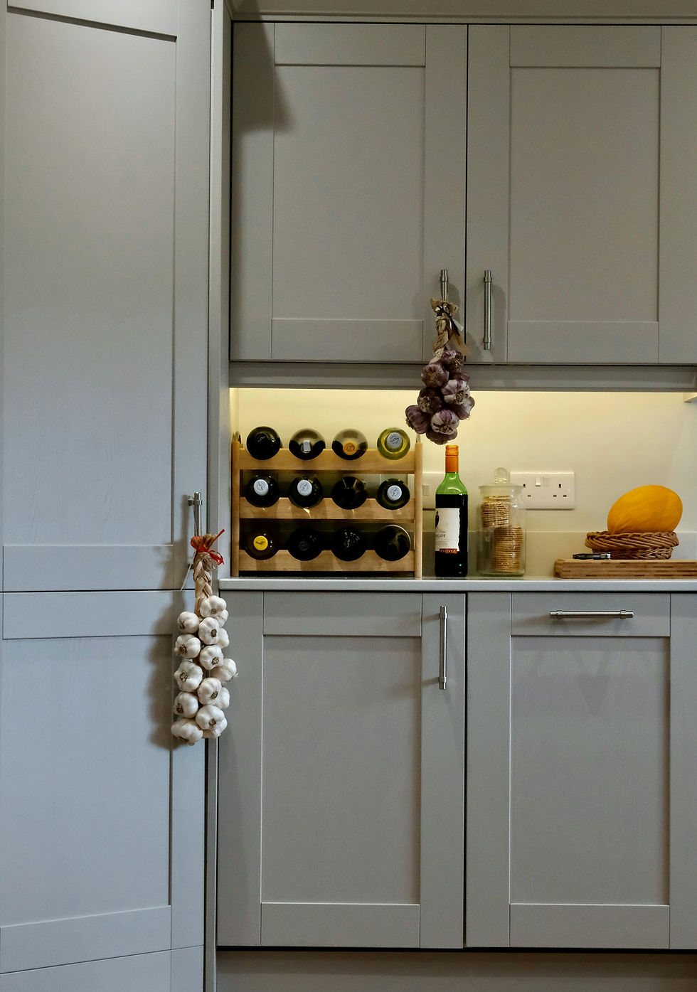 Modern grey kitchen cabinets with wine rack and garlic