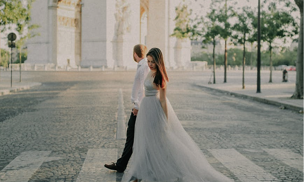 Couple crossing a Paris street near the Arc de Triomphe