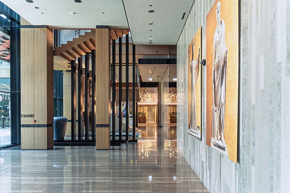 Modern building lobby with artwork and wooden staircase.