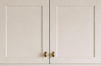 Close-up of white shaker cabinets with brass knobs