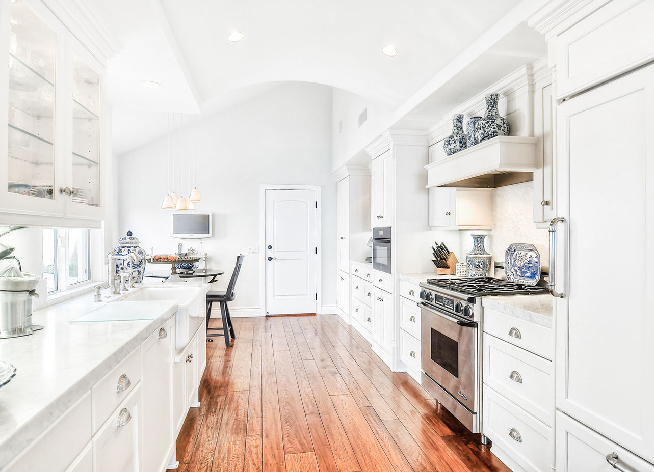 Elegant white kitchen with hardwood floors, bright and airy. Legourmet Kitchen.