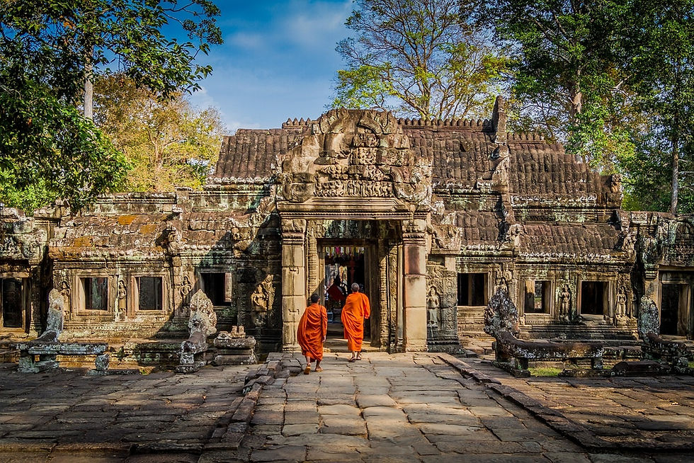 Two monks walking into an ancient temple in Cambodia during the day