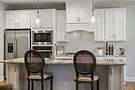Modern white kitchen with marble island and bar stools