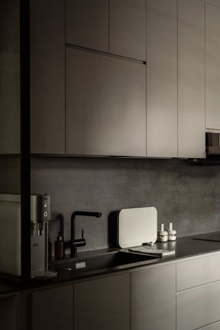 Modern minimalist kitchen with matte grey cabinets and sink.
