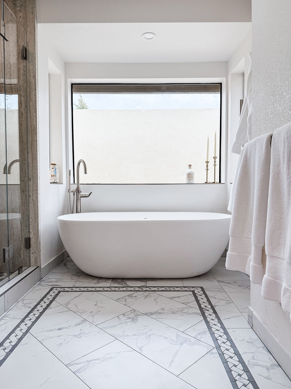 Modern bathroom with a bathtub, towels, and a large window. Legourmet Kitchen