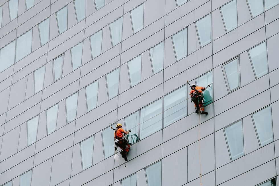 Two window washers rappelling down a modern skyscraper